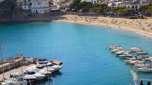 A coastal marina with boats docked and a beach in the background. - Ancora 07 in Llafranc (Palafrugell)