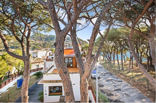 Une propriété située sur la côte, dotée d’une maison moderne, d’une allée pavée et offrant une vue sur la mer.