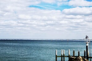 A view of a body of water with a bridge in the distance and a lighthouse on the right. - Appartement - Langstraat 5B Zoutelande (Zoutelande)