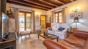 A spacious living area with a fireplace, a sofa, a coffee table, and a television. - Sa Xigala in Algaida (Algaida)