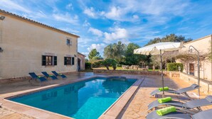 A rectangular swimming pool with clear blue water, surrounded by lounge chairs and an umbrella. - Sa Xigala in Algaida (Algaida)