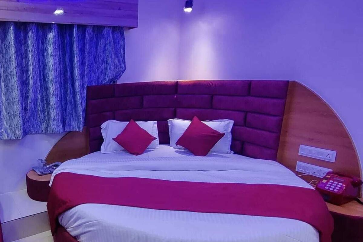 A modern bedroom with a large bed, a wooden headboard, and a built-in air conditioning unit.