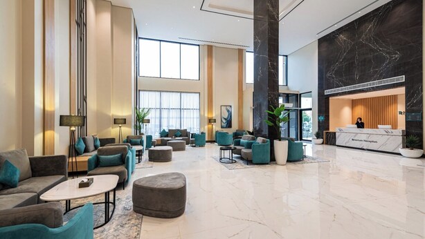A spacious lobby with a reception desk, seating areas, and large windows allowing natural light. - Rhenium Hotel (Riyadh)