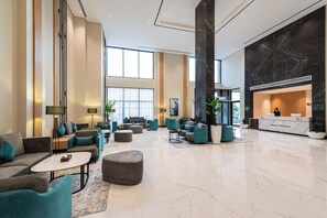A spacious lobby with a reception desk, seating areas, and large windows allowing natural light. - Rhenium Hotel (Riyadh)