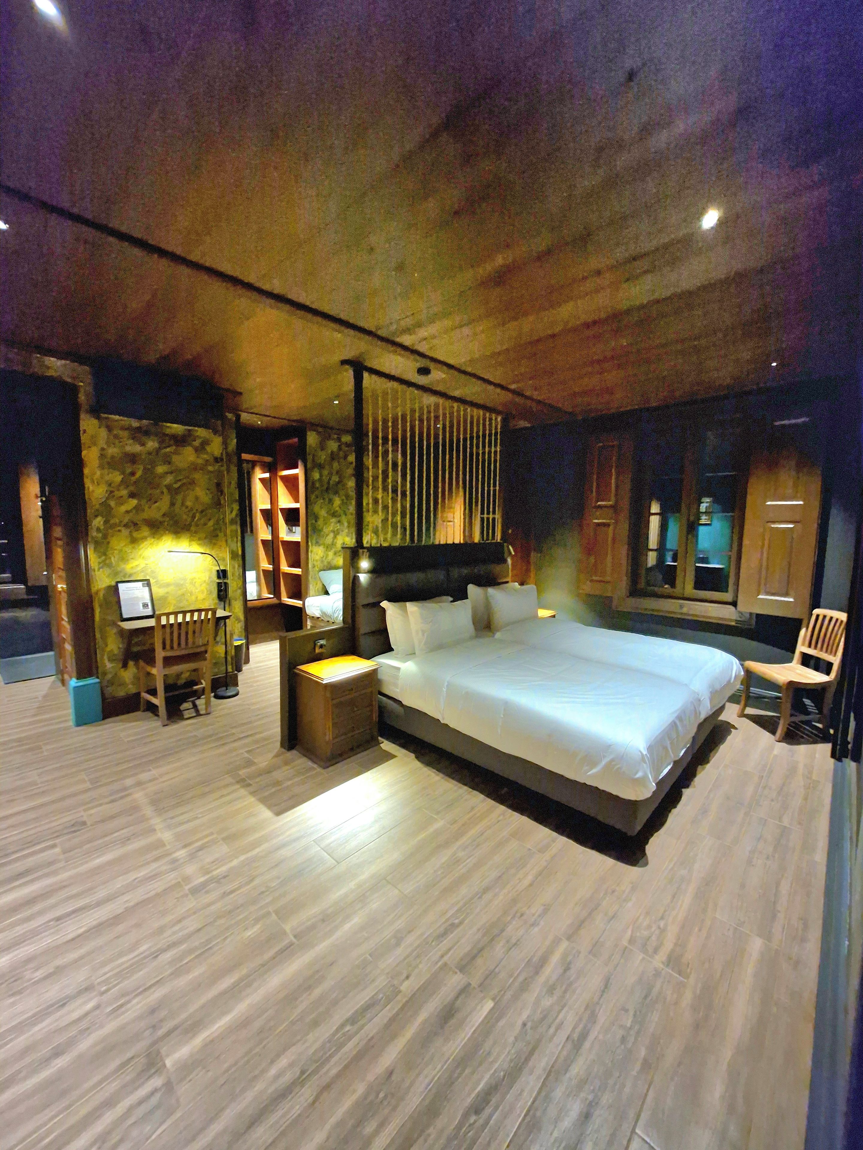 A spacious bedroom with a large bed, a desk, and a chair.
