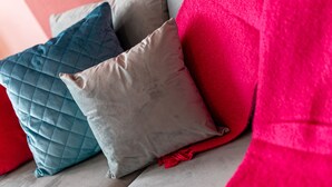 A section of a sofa with three cushions in different shades.