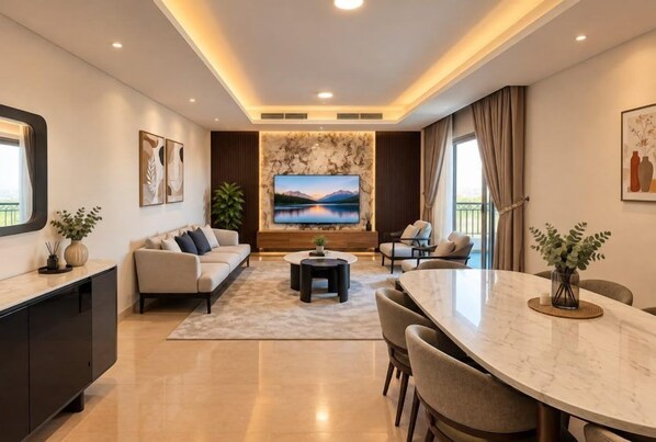 Una sala de estar moderna con sofá, televisor, mesa de comedor y sillas.
