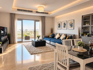 A modern living room with a sofa, coffee table, and dining area.
