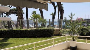 An outdoor dining area with a table set for four, surrounded by chairs. - SEAFRONT: T2 * * * , GARAGE, AIR-CONDITIONING, WI-FI (Frejus)