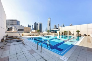 Ein Pool auf dem Dach mit Stadtansicht im Hintergrund.