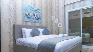 A bedroom with a bed, a painting, and a sliding glass door.