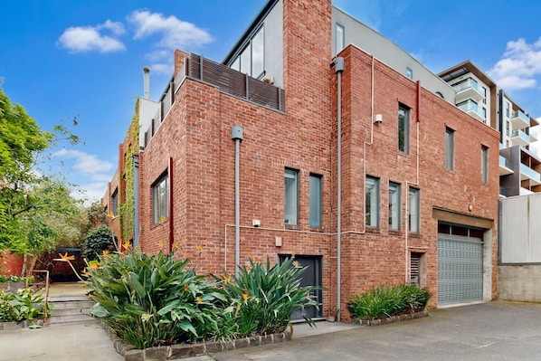 A modern brick building with large windows and a garage door.