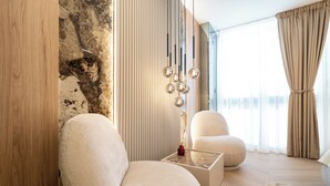 Una sala de estar moderna con un ventanal grande, un sofá, una mesa de centro y una lámpara decorativa.
