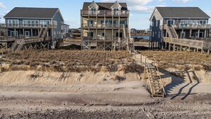A beachfront property with multiple buildings featuring balconies and wooden walkways.