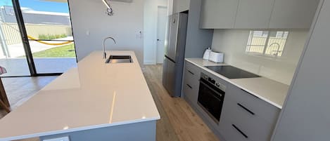 Een oven, een vaatwasser, een broodrooster, kookgerei, borden en bestek