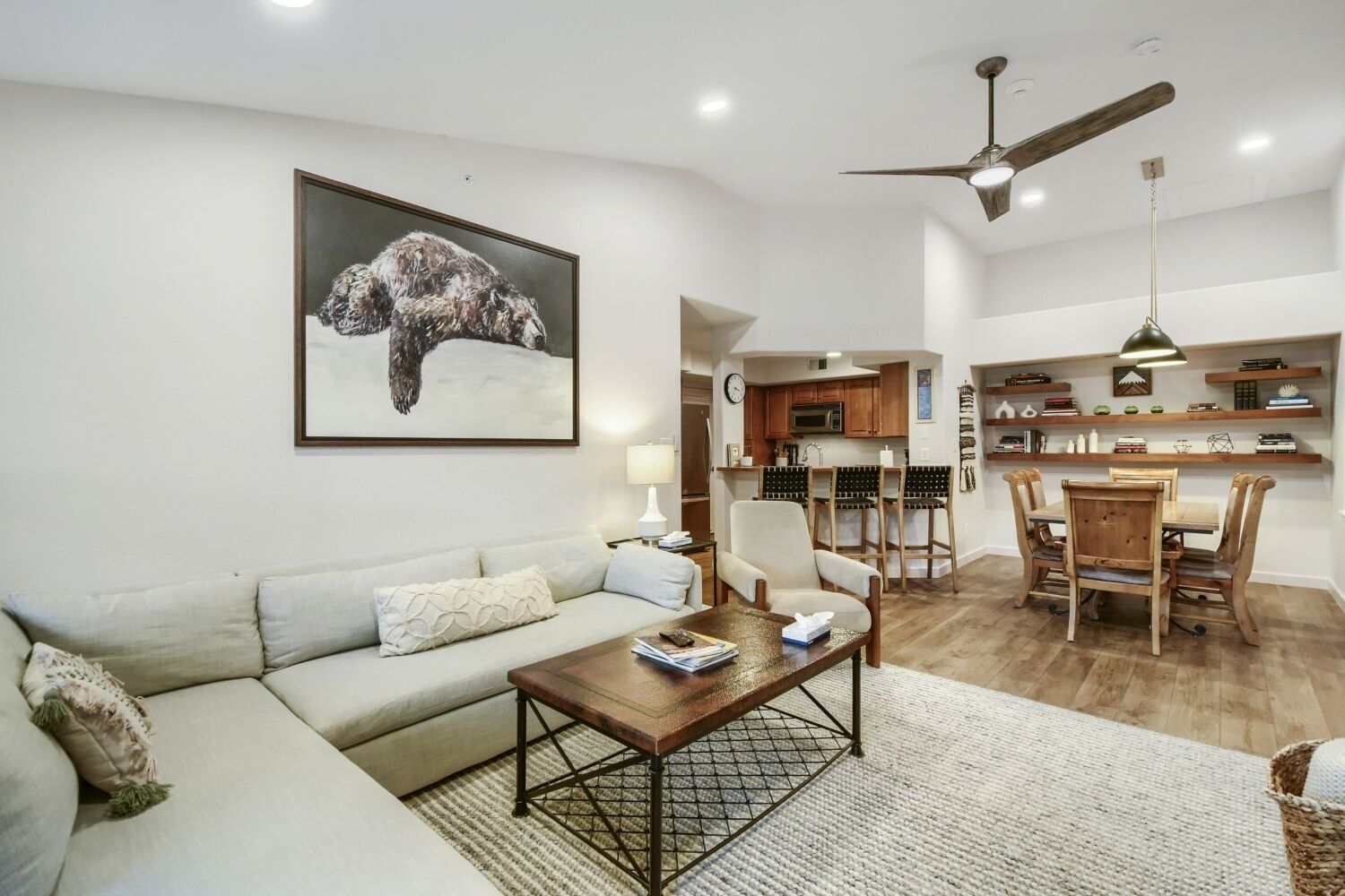 Un salon avec un canapé, une table basse et un tableau représentant un chien.