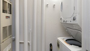 A laundry room with a washer and dryer, white walls, and a vented heater. - River Pines A303 3 Bedroom Condo (Edwards)