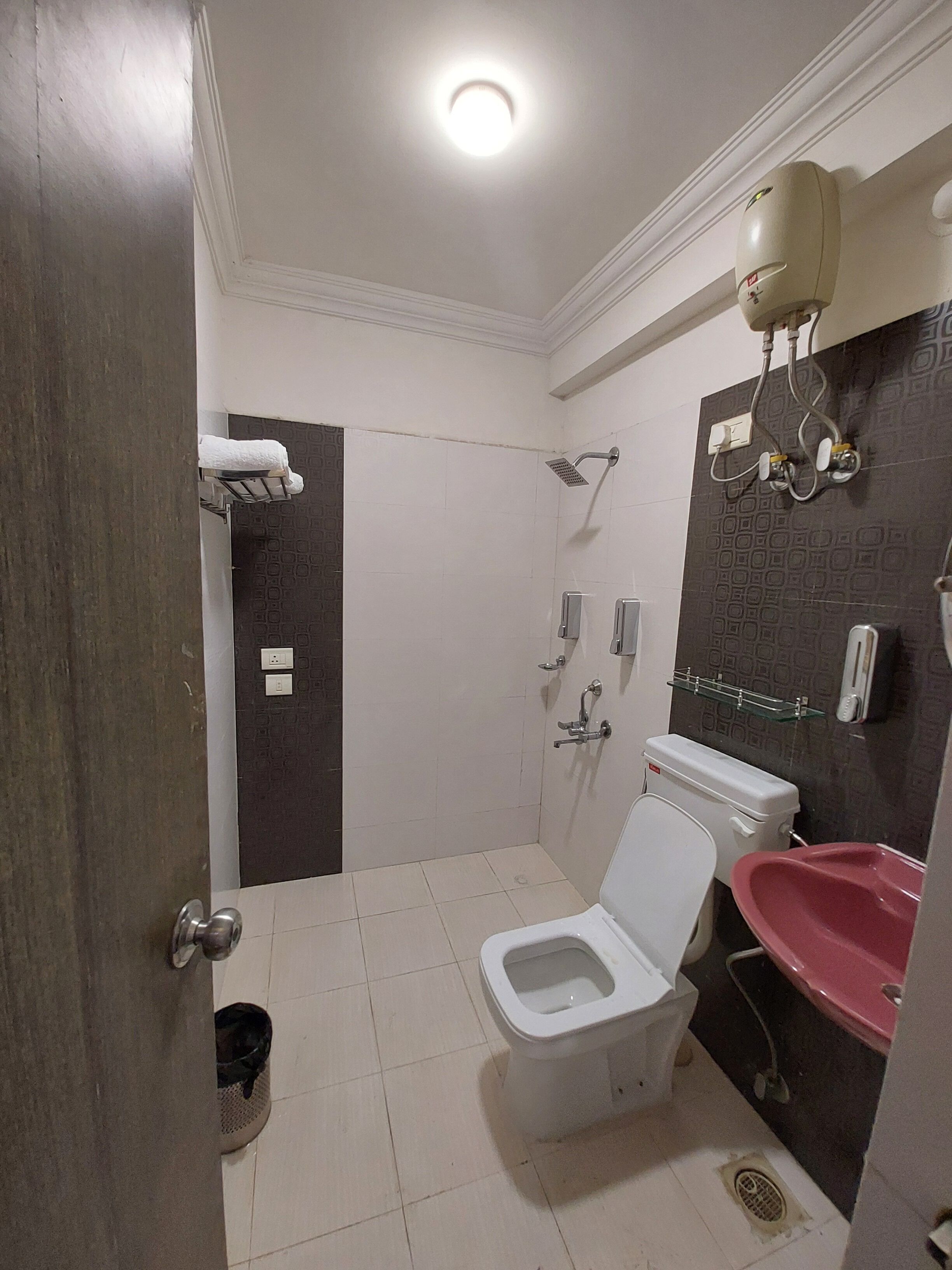 A bathroom with a toilet, shower, and sink.