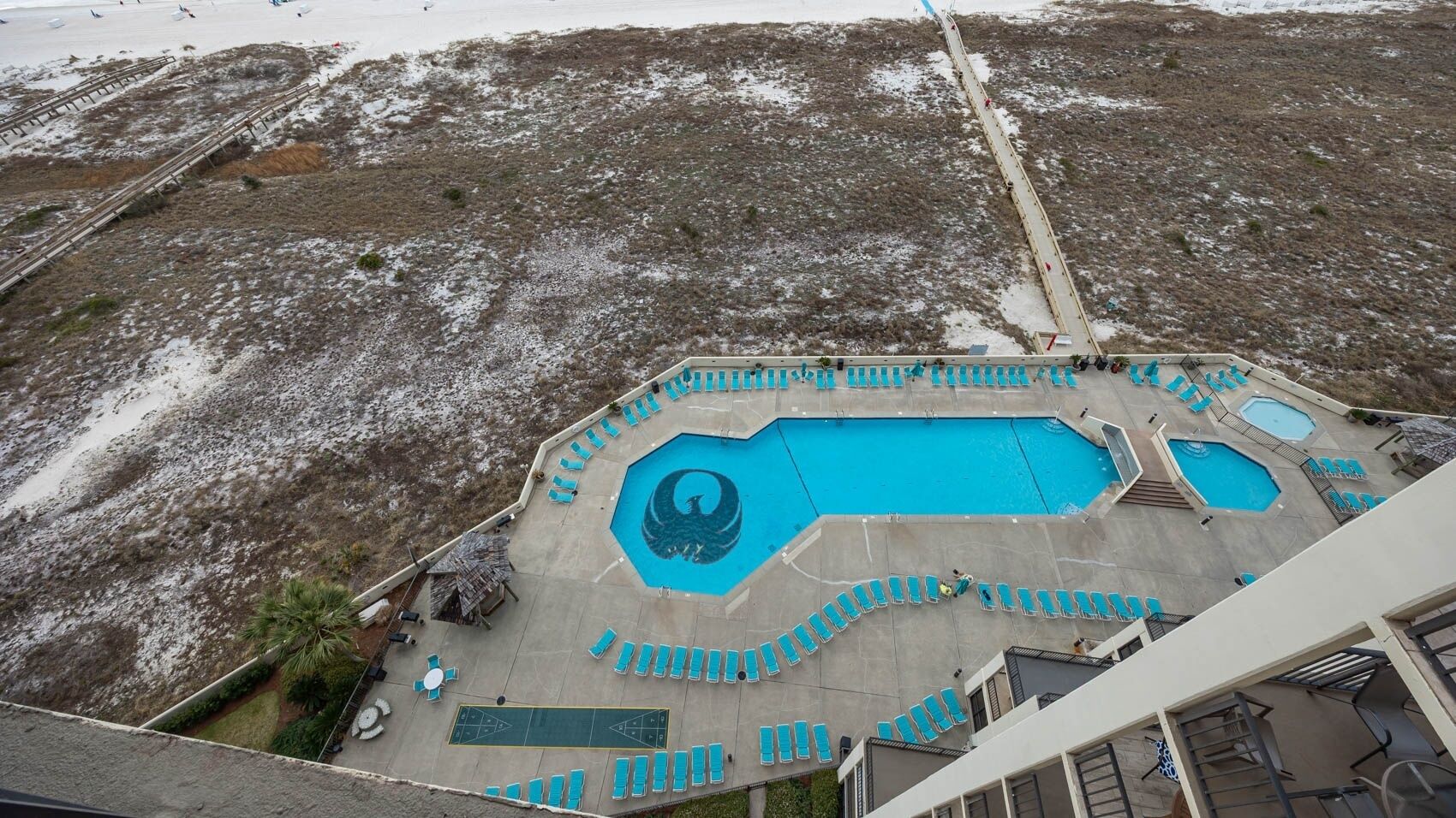 Ein Resort mit einem großen, achteckigen Pool mit einzigartigem Design, umgeben von mehreren kleineren Pools und Liegestühlen.
