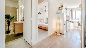A modern apartment with a kitchen, dining area, and a bedroom. - Wisdom Monkeys Apartment - Balcony & AC (Toulon)