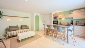 Un appartement moderne comprenant un espace de vie, un coin repas et une cuisine.
