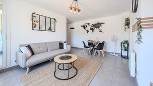 A modern living room with a sofa, coffee table, and dining area. - The Port Marchand Escapade - Air-conditioned flat (Toulon)