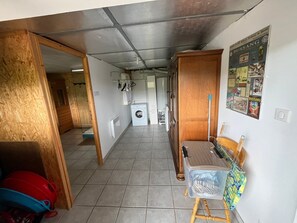 A laundry room with a washing machine, drying rack, and wooden cabinets. - Entire chalet, panoramic views, stream and sauna. (Bussang)