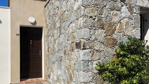 Un bâtiment en pierre doté d’une porte et d’un escalier menant à un porche.
