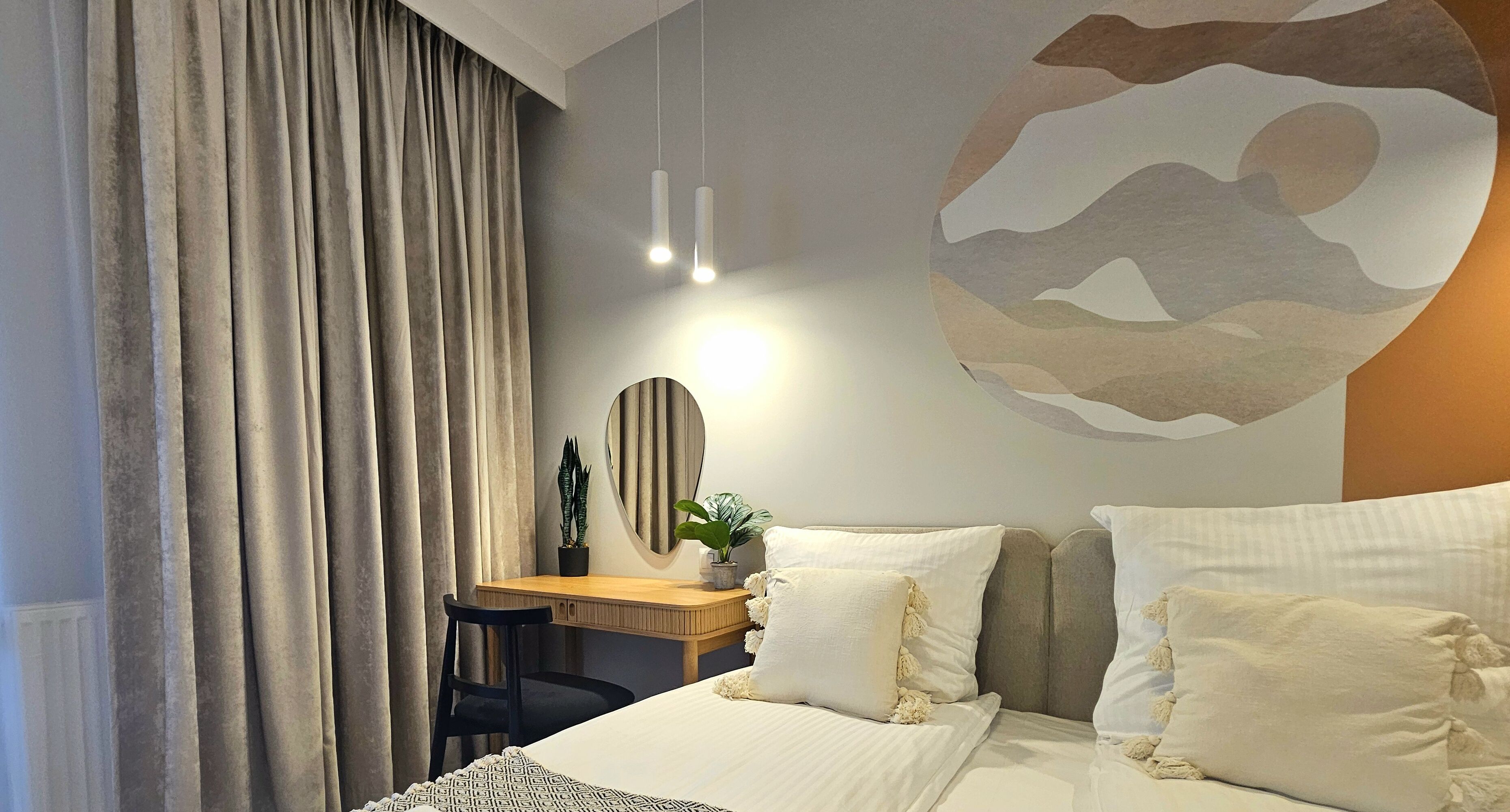 Una habitación de hotel moderna con una cama grande, un escritorio y un espejo.