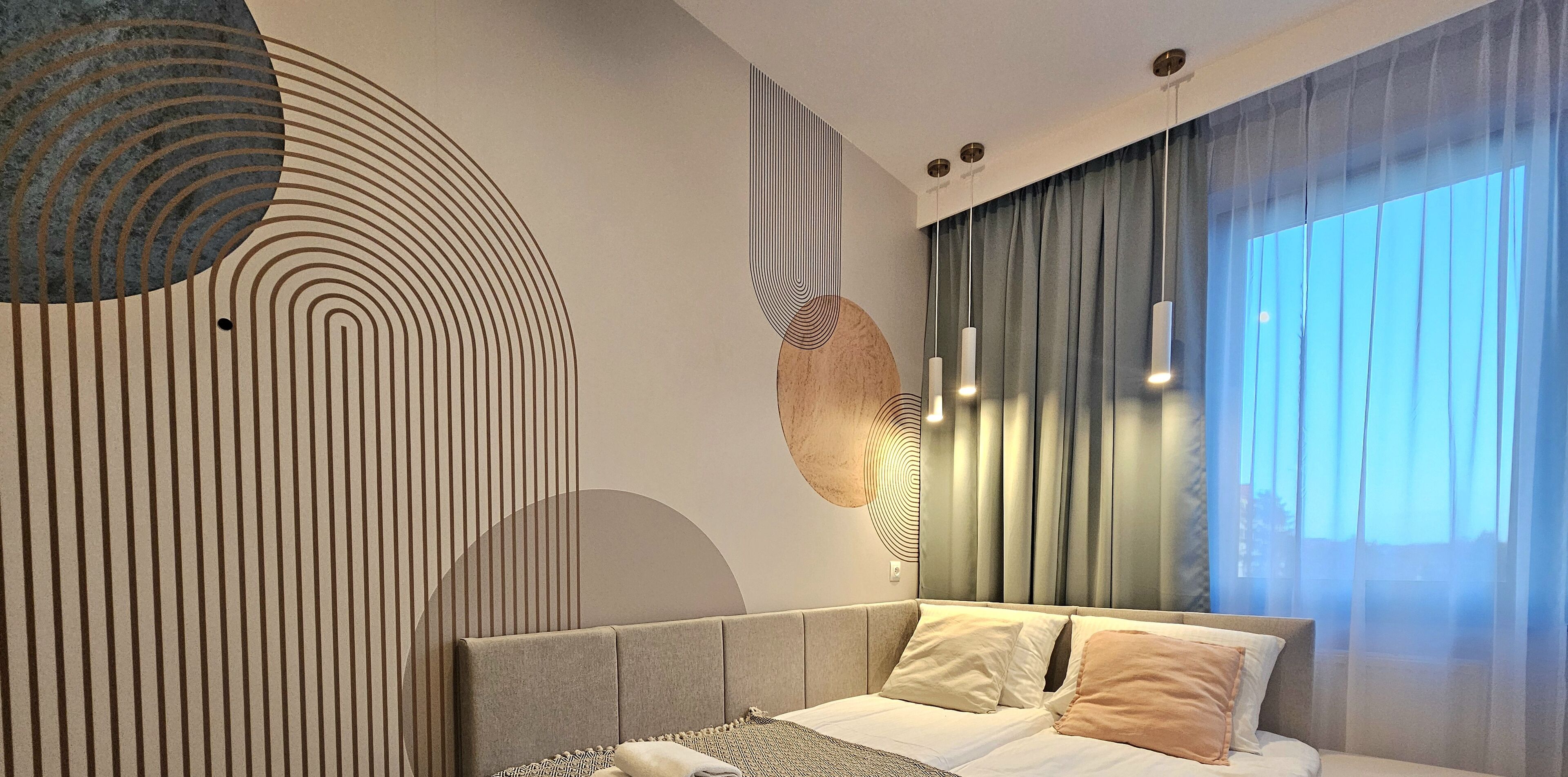 Une chambre à coucher moderne avec un lit, des rideaux et des œuvres d’art murales.