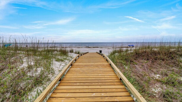 A wooden boardwalk leading to a beach with sand and sparse vegetation on either side. - Cozy Beach Retreat with Tennis! Short walk to the beach! (Hilton Head Island)