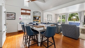A dining area with a wooden table, blue chairs, and a ceiling fan. - CASA DEL SUR ~ Renovated 2 BR/2Ba Home with Heated Dip Pool! (Key West)