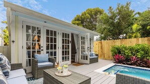 A patio area with wicker furniture, a pool, and a wooden fence. - CASA DEL SUR ~ Renovated 2 BR/2Ba Home with Heated Dip Pool! (Key West)