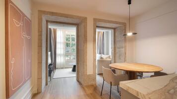 Un interior moderno con comedor, sofá y vistas a través de una puerta.