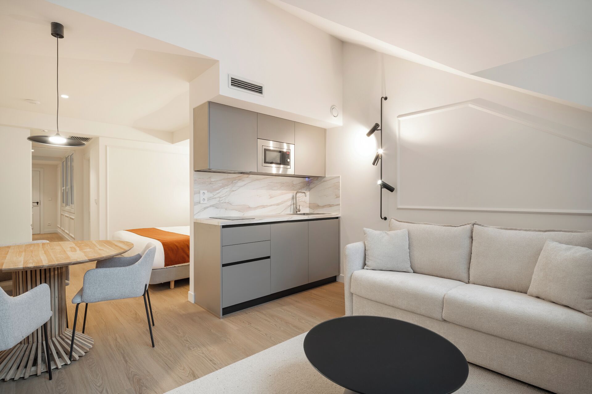 A modern apartment with a kitchen, dining area, and living room.