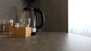 A kitchen counter with a coffee maker, measuring cups, and a wooden box. - Hotel Löwenstein (Lich)