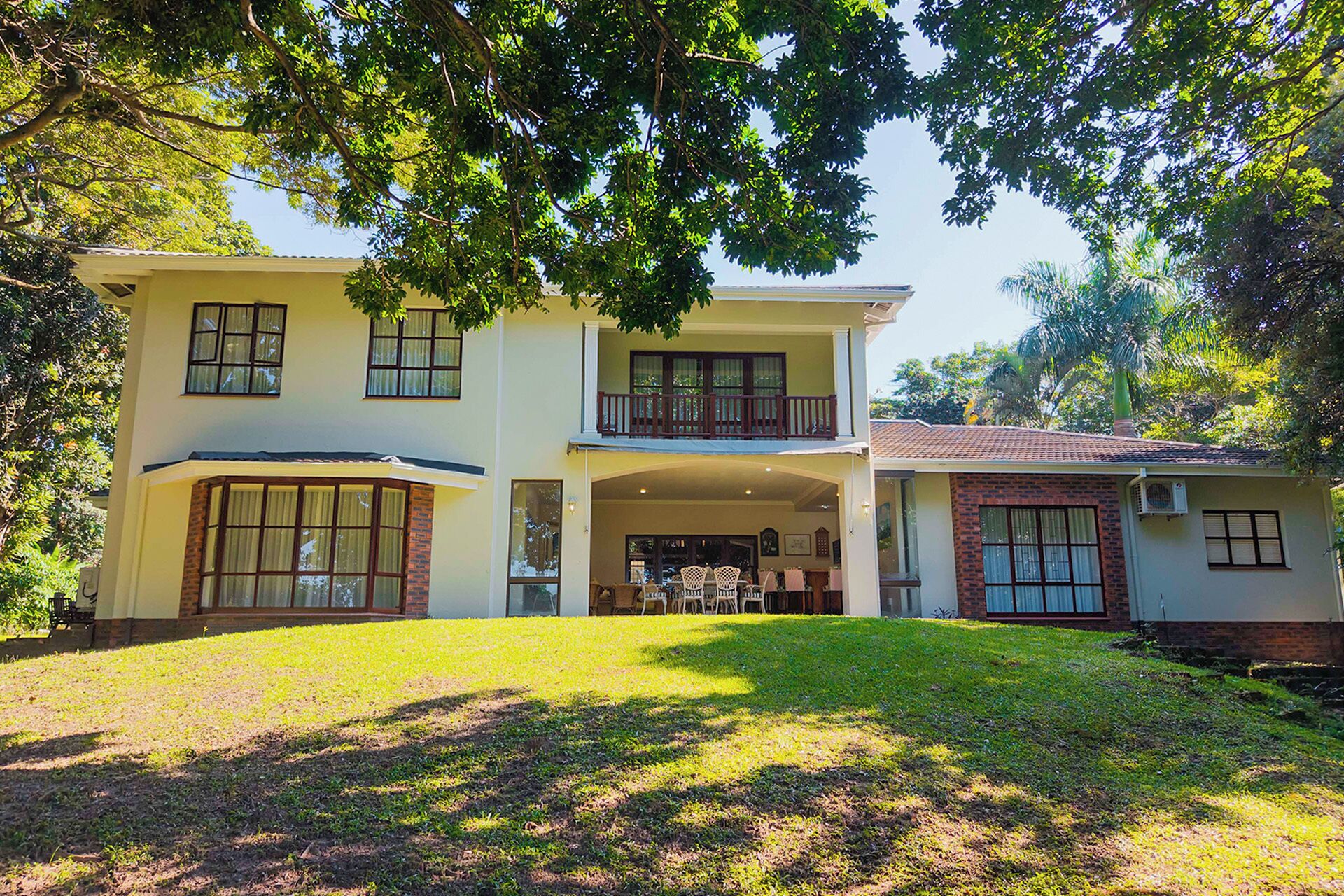 A two-story house with a covered patio and a small attached structure.