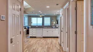 Una cocina con armarios blancos, encimera de granito y vistas al exterior.