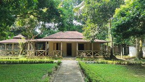 A rustic building with a tiled roof and a porch with wooden railings. - Kazi Resort & Hotel (Kapasia)