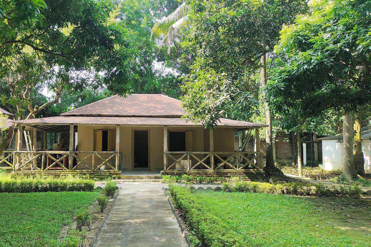 A rustic building with a tiled roof and a porch with wooden railings.