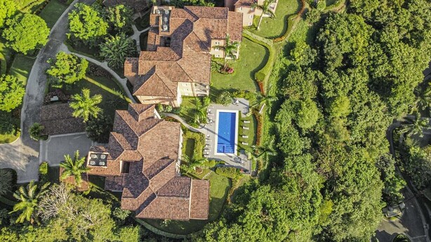 Um bairro residencial com várias casas, piscina e áreas verdes ao redor.