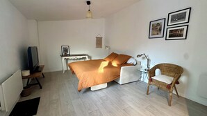 Une chambre à coucher comprenant un lit, un bureau, une chaise et un téléviseur.