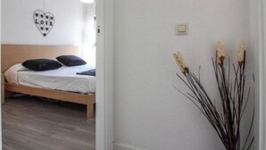 Une chambre à coucher avec un lit, un décor mural en forme de cœur portant le mot «
AMOUR
», et un luminaire fixé au mur.