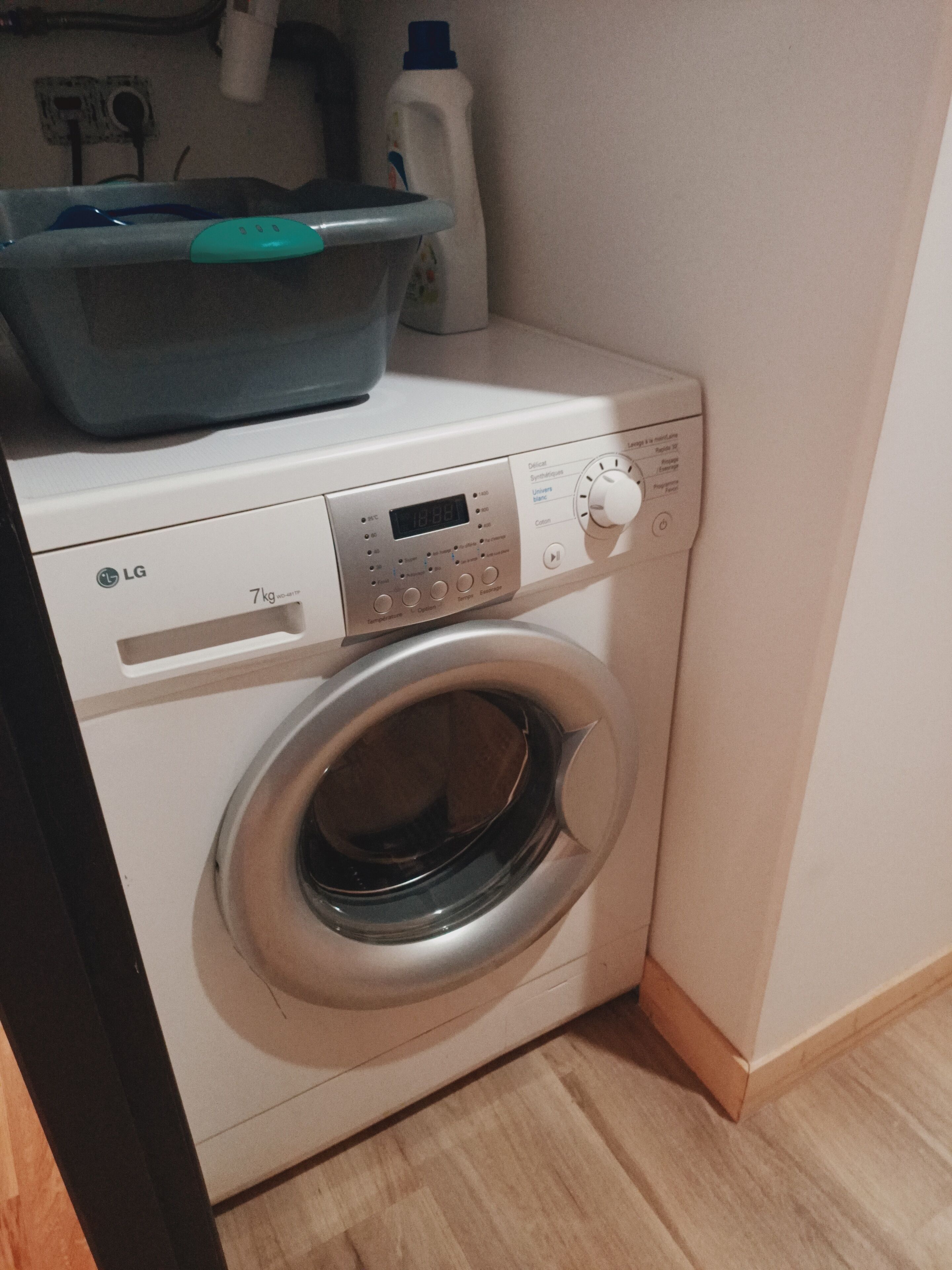 A front-loading washing machine with a digital display, control panel, and a 7kg capacity label.