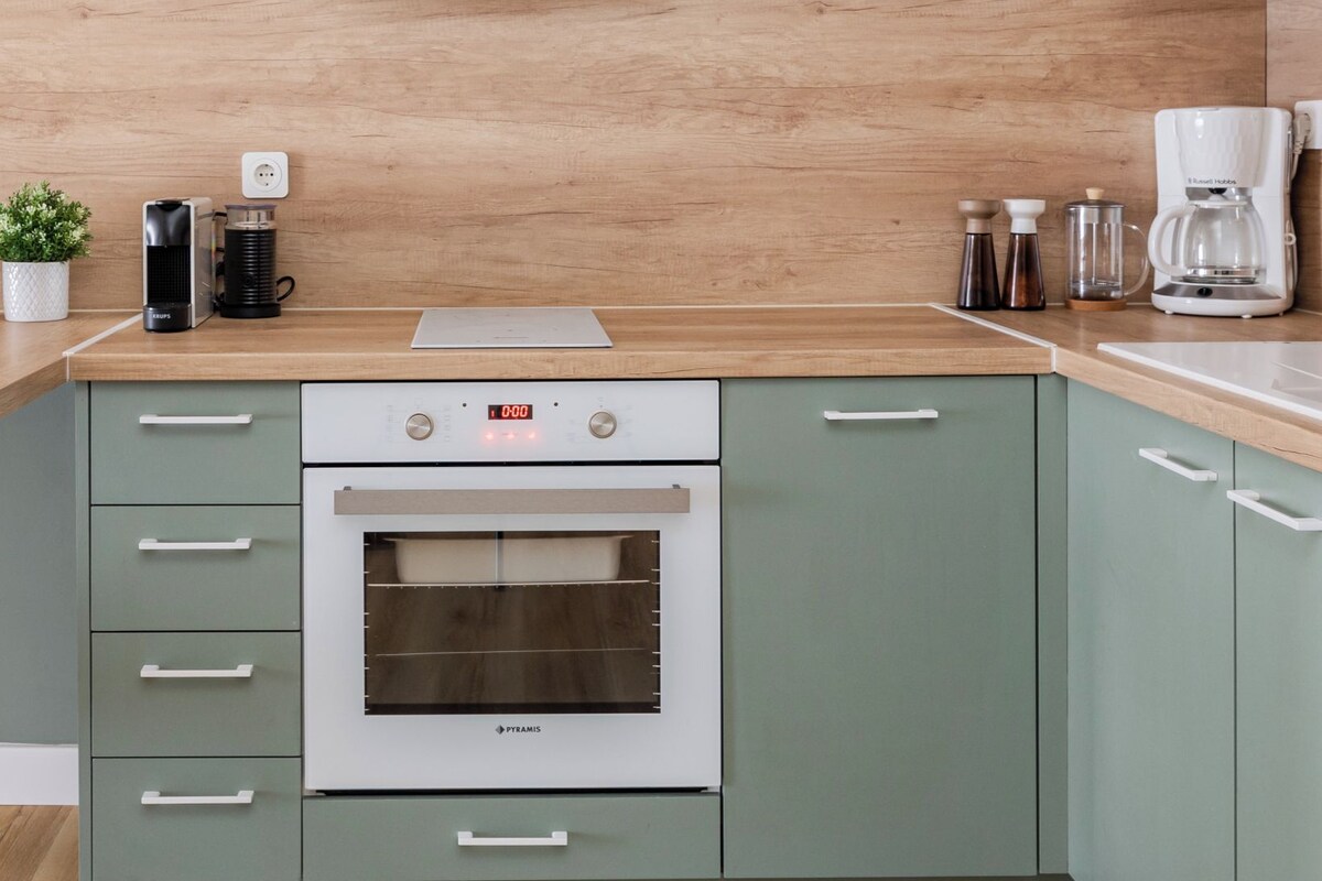 A kitchen with a built-in oven, a microwave, and a coffee maker on the countertop.