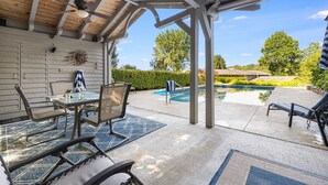 A covered patio with a pool, outdoor furniture, and a view of the pool area. - Daisy Farm | Pool, Hot Tub & Animals 🐴 + Biltmore Pass Near Asheville (Candler)