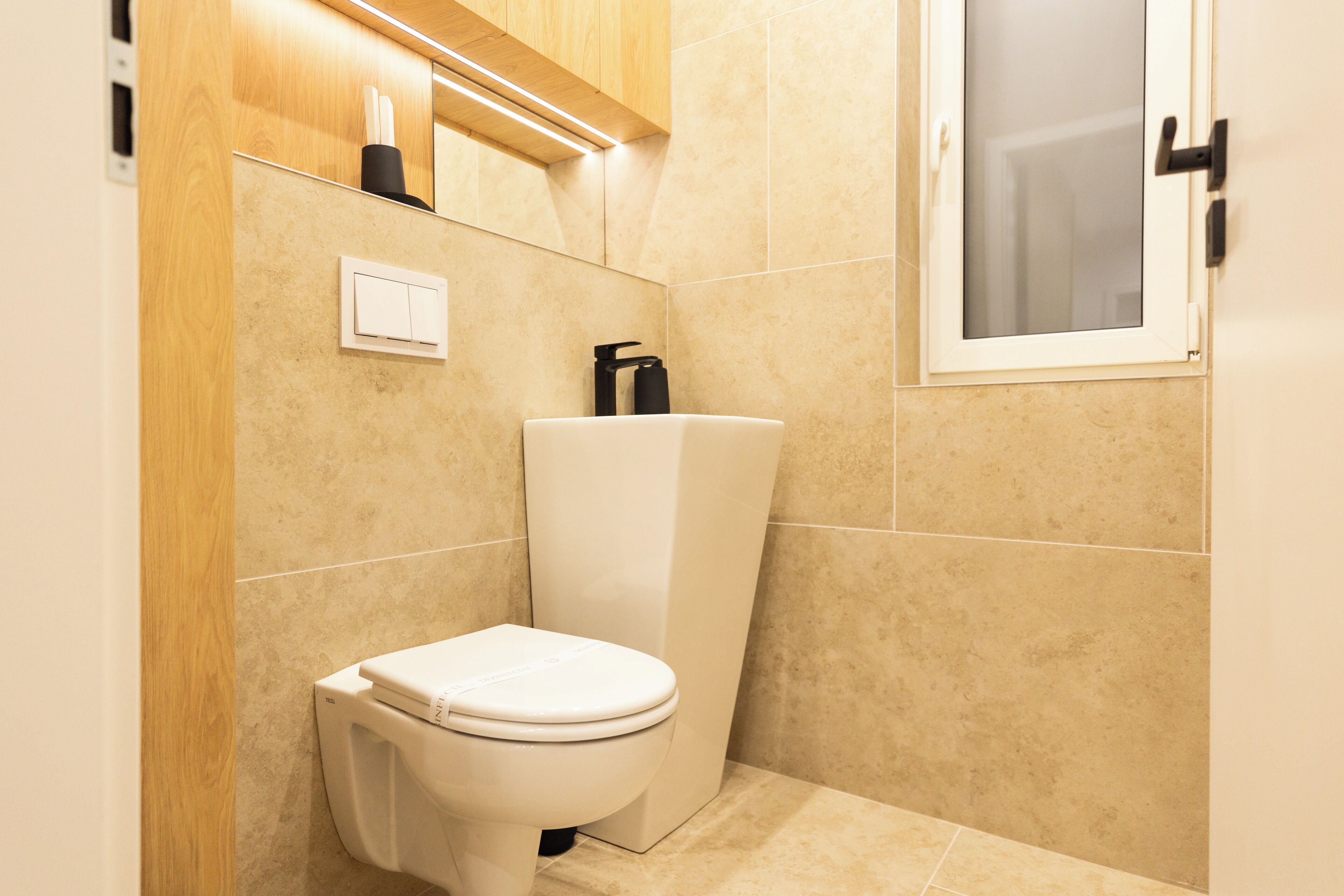 Un baño moderno con inodoro, bidé y ventana.