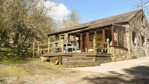 A rustic stone building with a wooden deck and a thatched roof. - Red Squirrel Haven 2BR House - Sleeps 4 - Parking (Hawes)