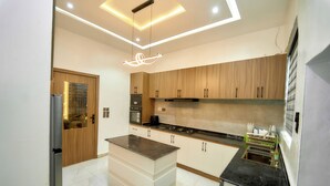 A modern kitchen with wooden cabinets, a central island, and a built-in dishwasher.