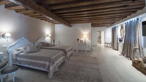 A bedroom with two beds, wooden beams on the ceiling, a desk, and a chair. - Savoia & Jolanda Apartments  (Venice)